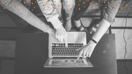 Hands pointing to something on a laptop screen